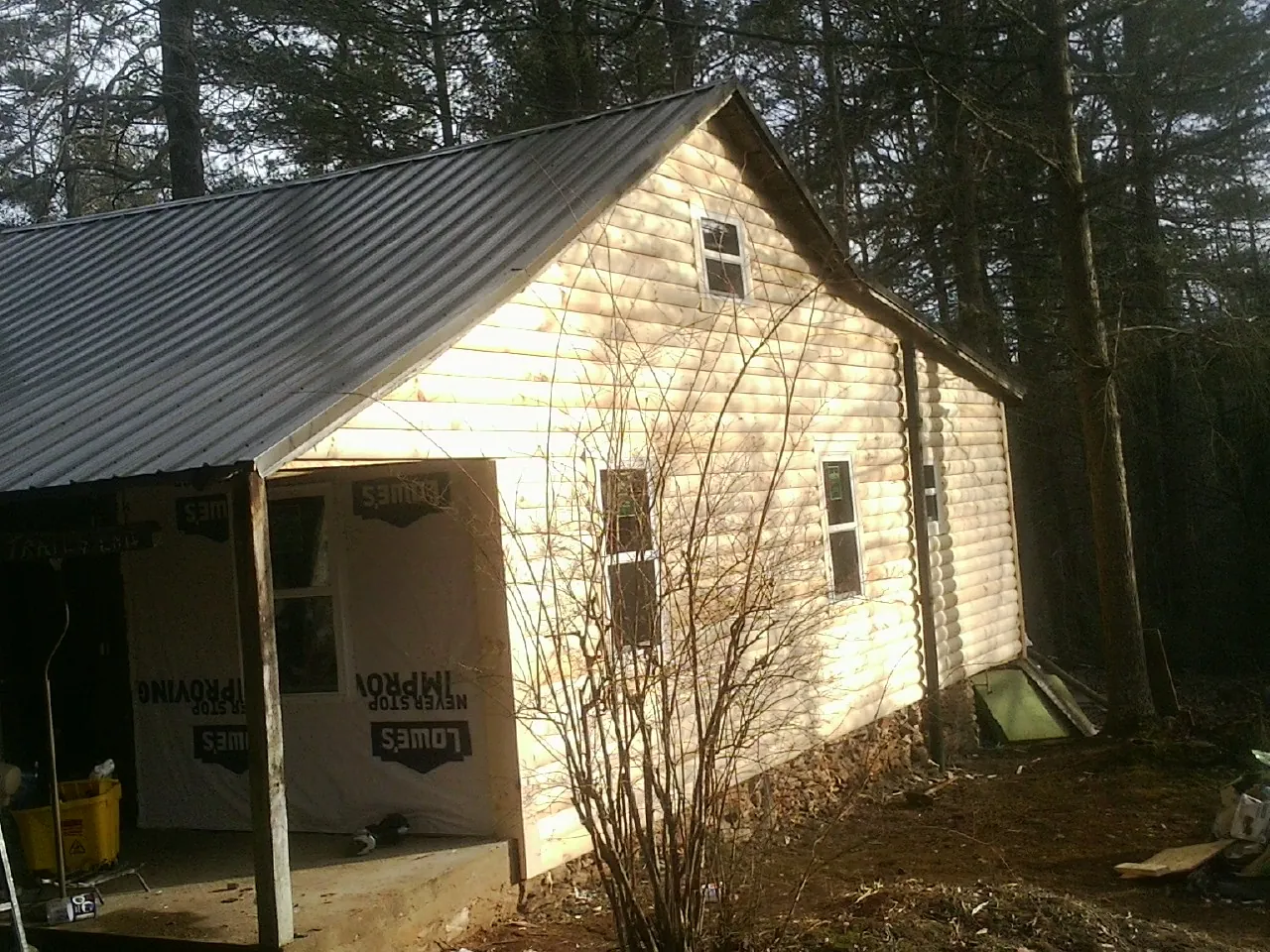 Log siding gable end under a dark metal roof edge in Conway